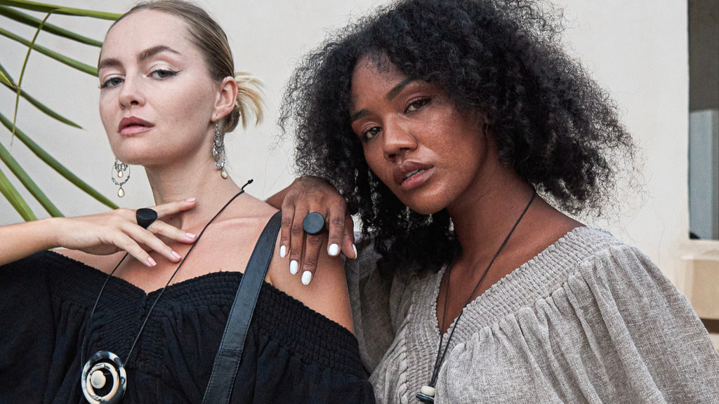 Two models wearing 'Alice' crop tops in black and taupe colors, with one model also wearing a necklace that appears to be made of the same material as the top.